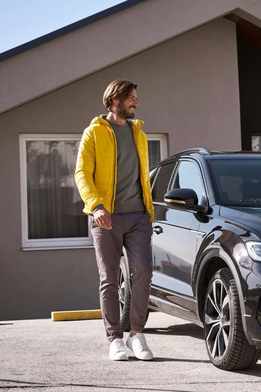 Žena so smartfónom a muž vedľa auta VW