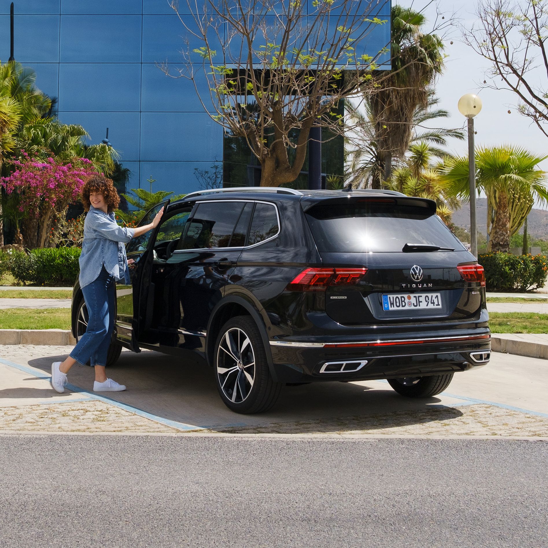 Žena otvára dvere vodiča na vozidle VW Tiguan Allspace