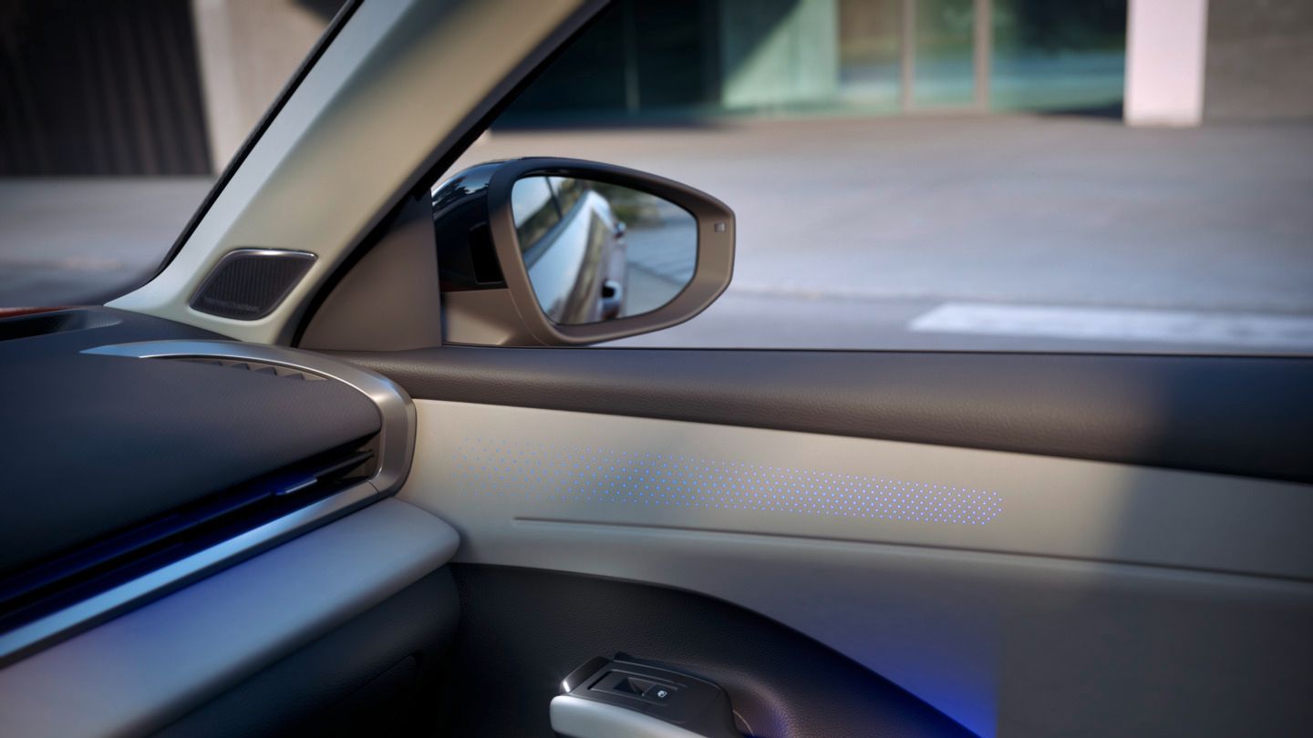 Pohľad do interiéru Volkswagen T-Roc Style s detailom na dvere s modrým ambientným osvetlením.