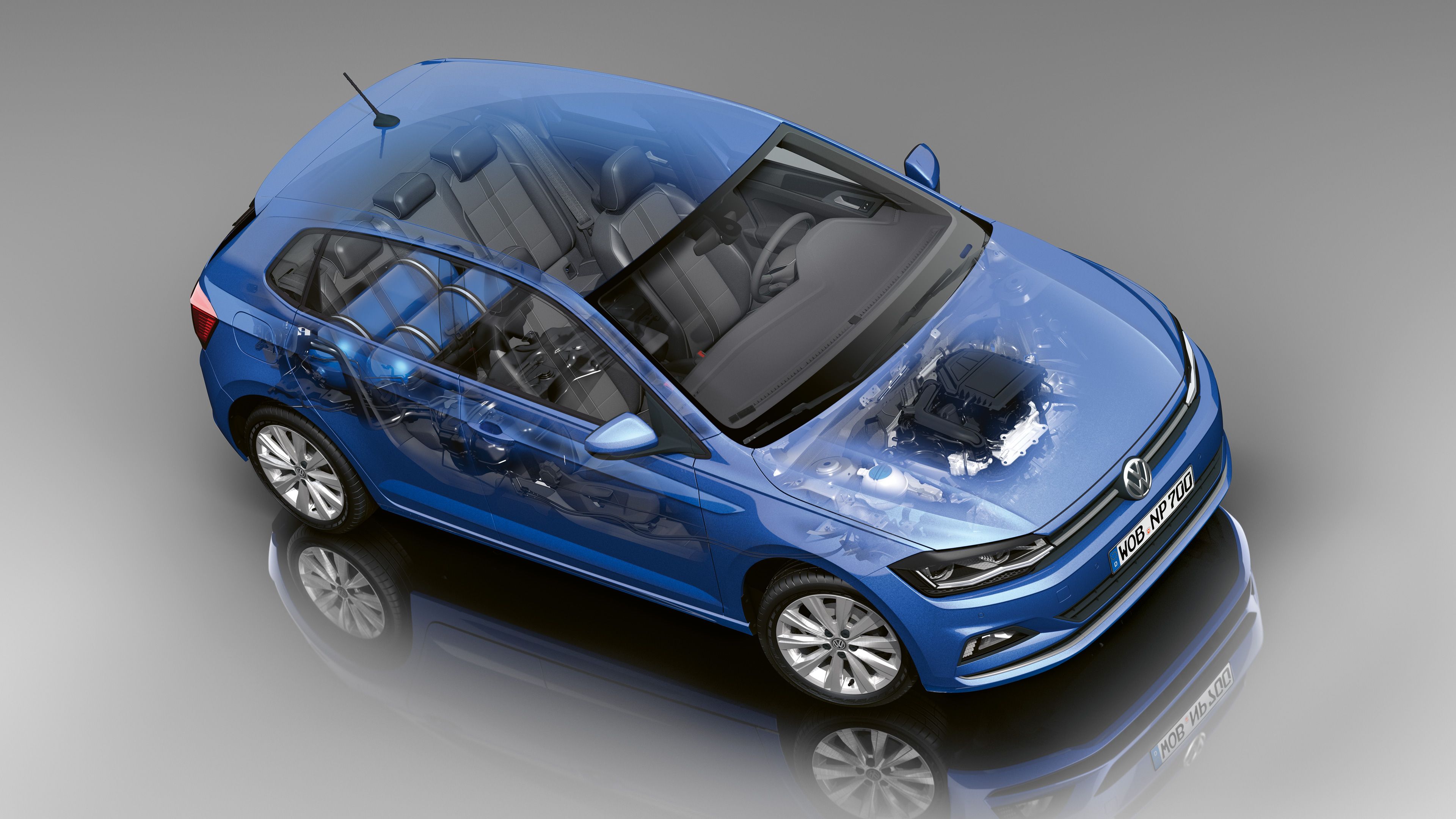 Čiastočne transparentný osobný automobil, ktorý odhaľuje vnútorné komponenty vozidla, vrátane sedadiel, motora a prevodovky. Automobil je zobrazený na šedom neutrálnom pozadí.