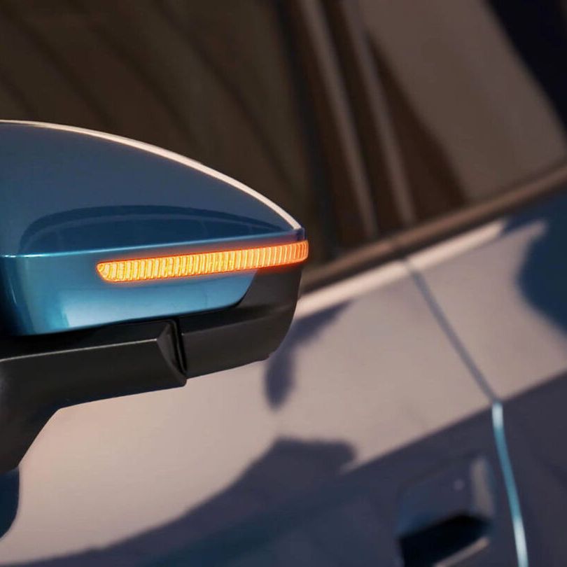 Bočné zrkadlo modrého ID.4 so zapnutými výstražnými svetlami.