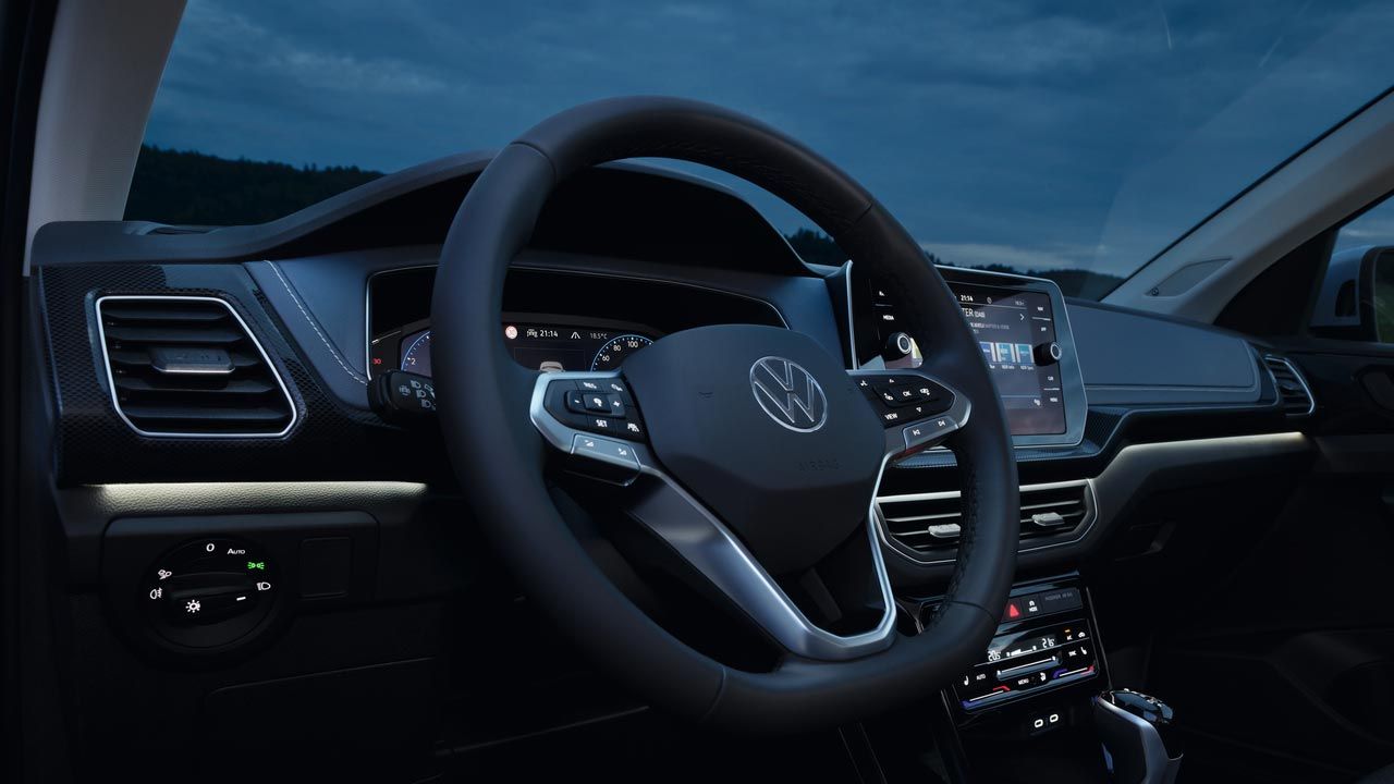 Detailný pohľad na vnútorný priestor vodiča VW T-Cross v noci so zameraním na biele ambientné osvetlenie