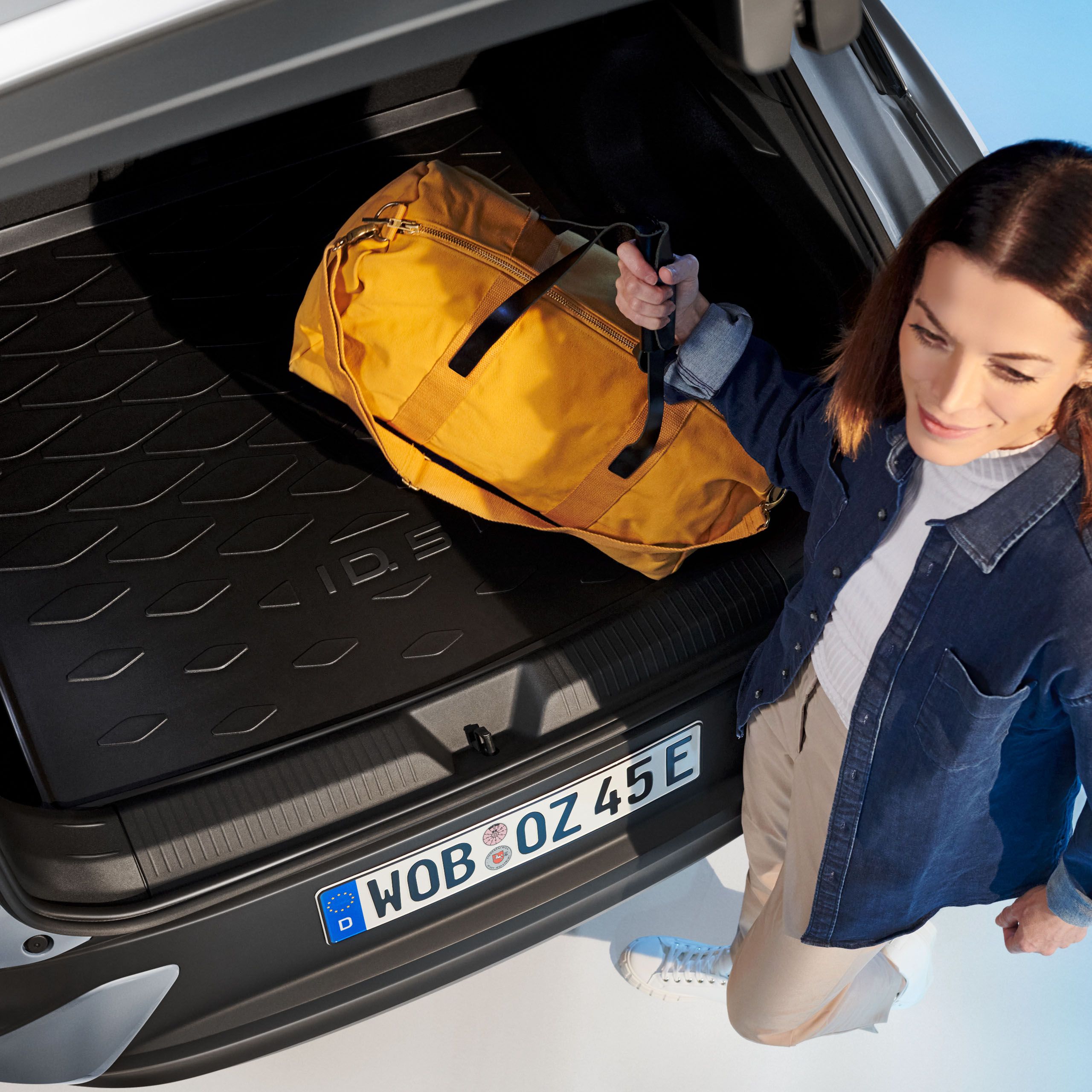 Žena ukladá tašku do batožinového priestoru – riešenia batožinového priestoru od Volkswagen