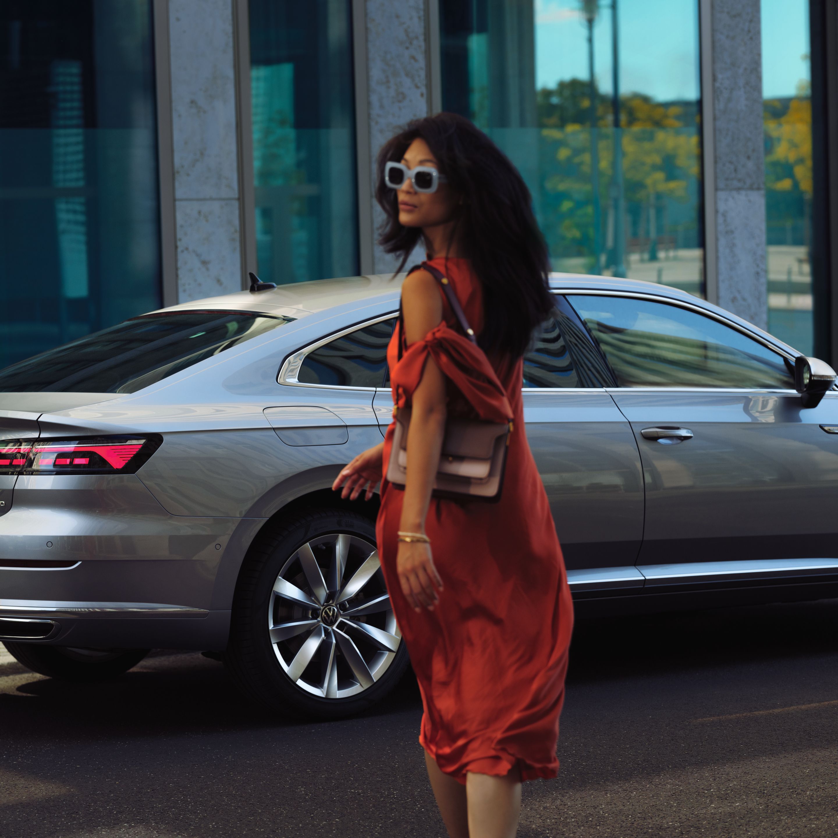 Žena kráča k striebornému vozidlu Volkswagen Arteon.