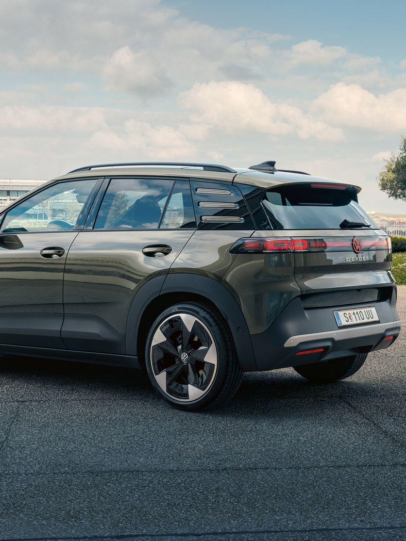 Pohľad zozadu na zelené VW ID. Cross zaparkované na námestí so zelenými stromami.