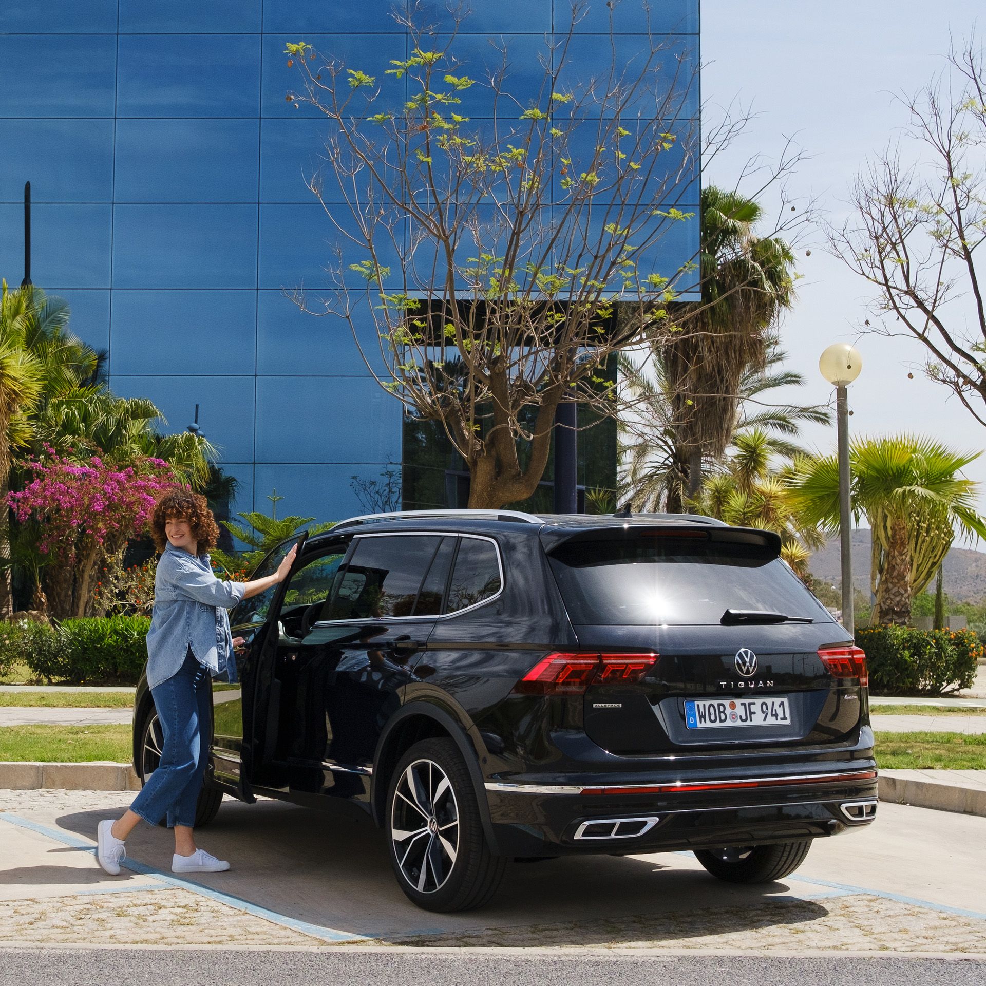 Žena otvára dvere vodiča na vozidle VW Tiguan Allspace
