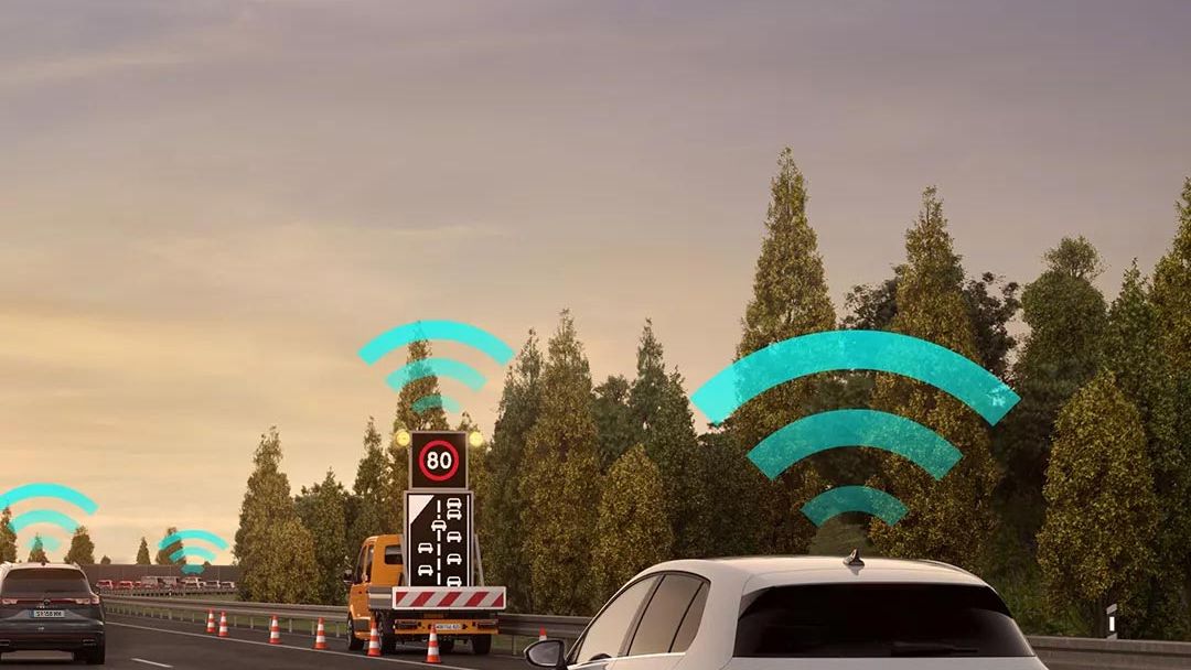 Vozidlo VW Golf jazdí v jazdnom pruhu na diaľnici. Nad autom sú ikony znázorňujúce pripojenie na internet. V pozadí je nákladné auto a stromy.